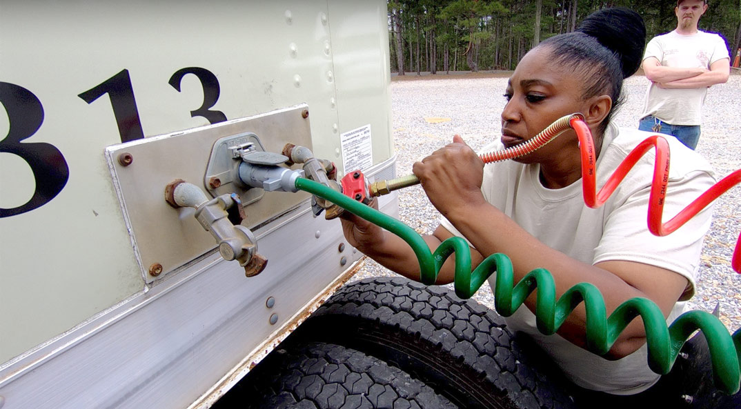 Reid State Trucking female connecting a coil to the truck