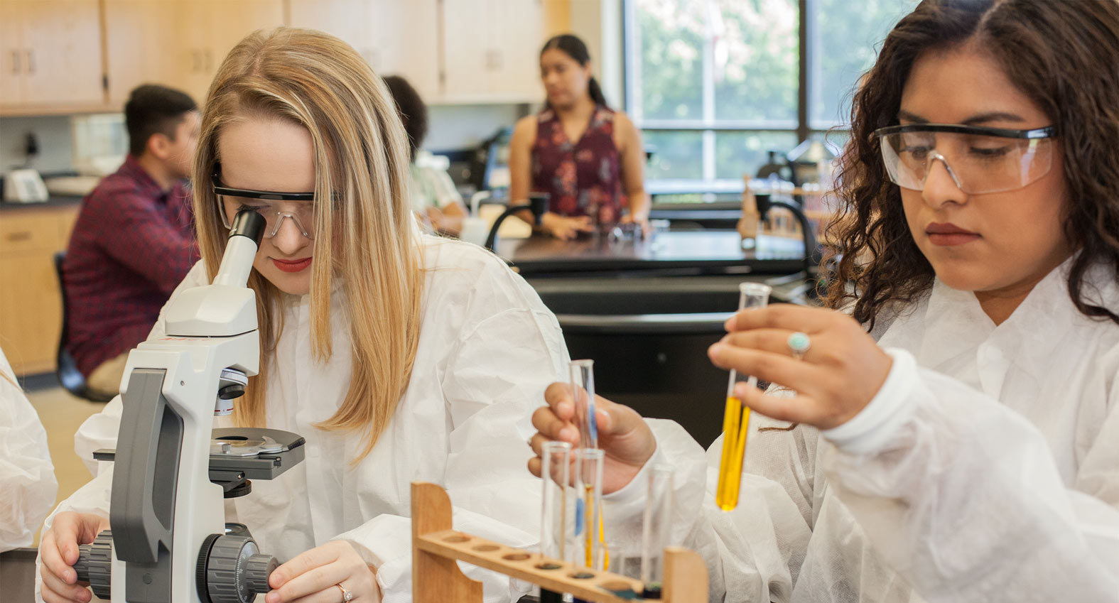 Girls in lab observing test tubes