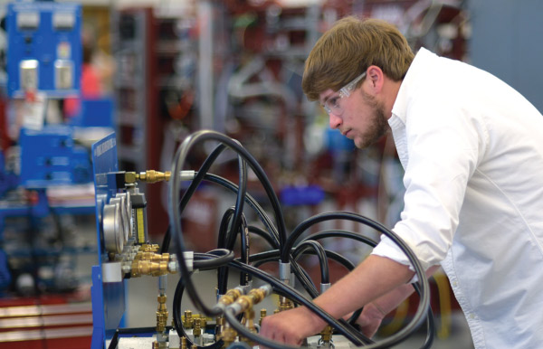 Technical training, student wearing goggles looking at wires and cords