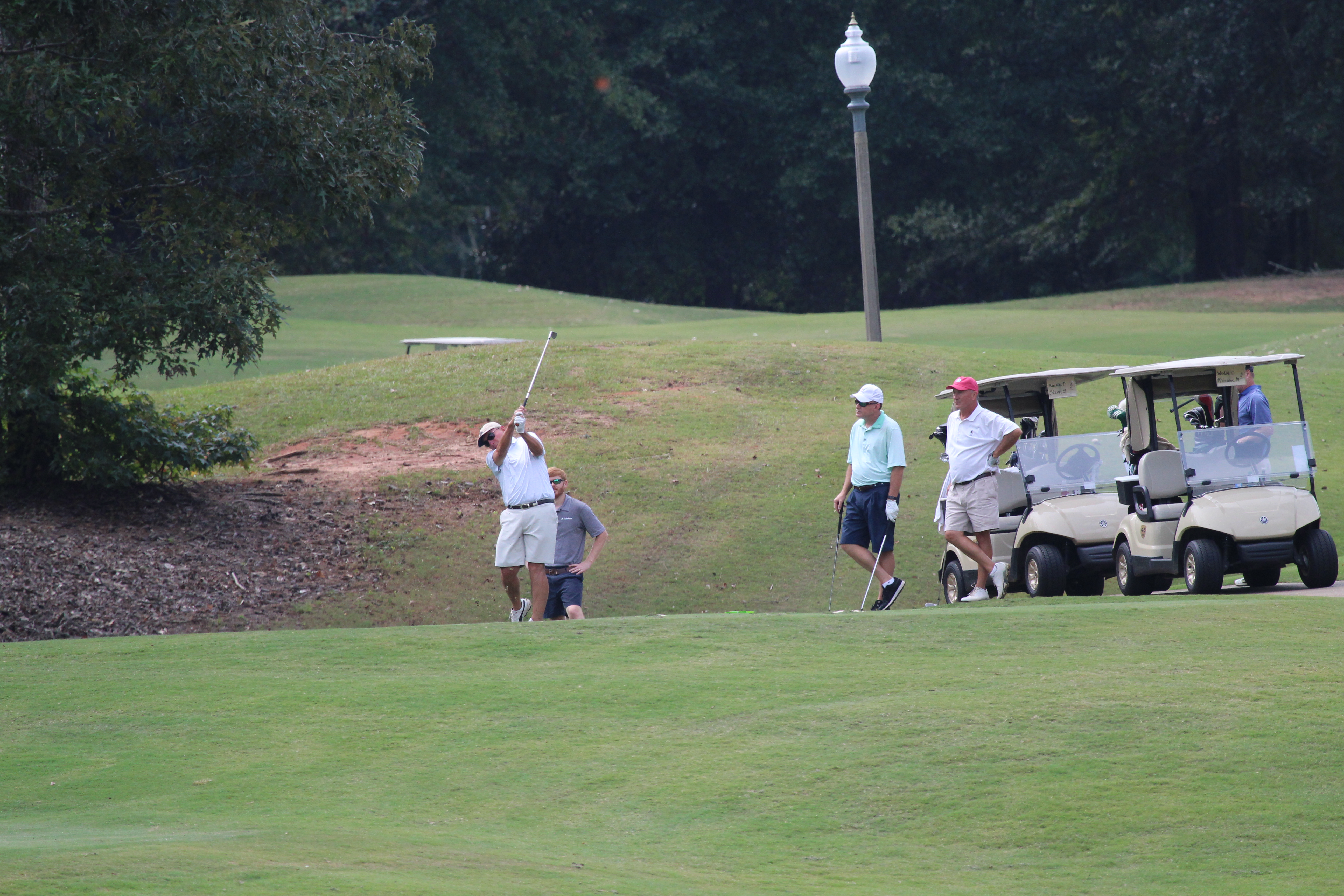 Image of male golfers swinging clubs on the green