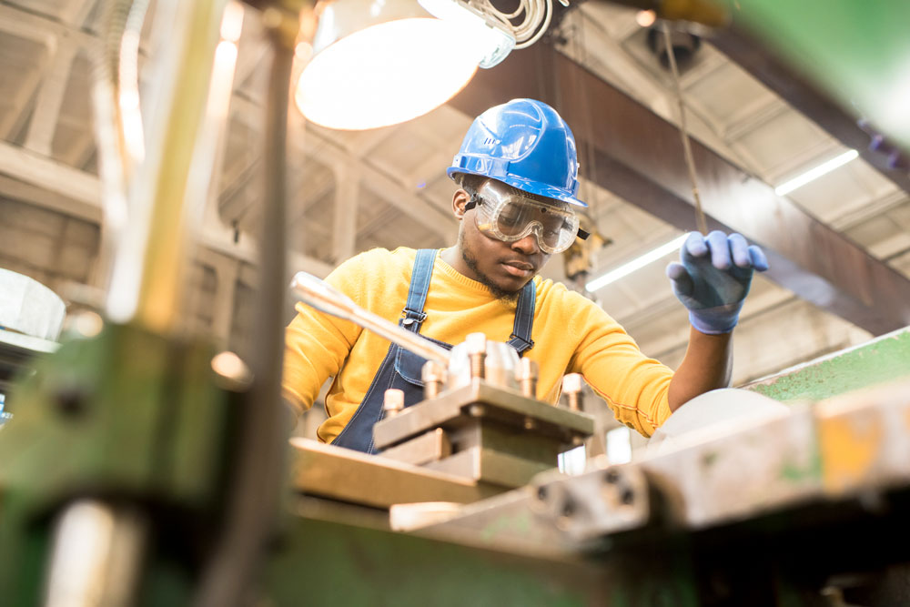 serious-worker-repairing-manufacturing-machine-NRTSVPC